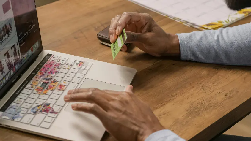 a man doing payments with credit card on laptop