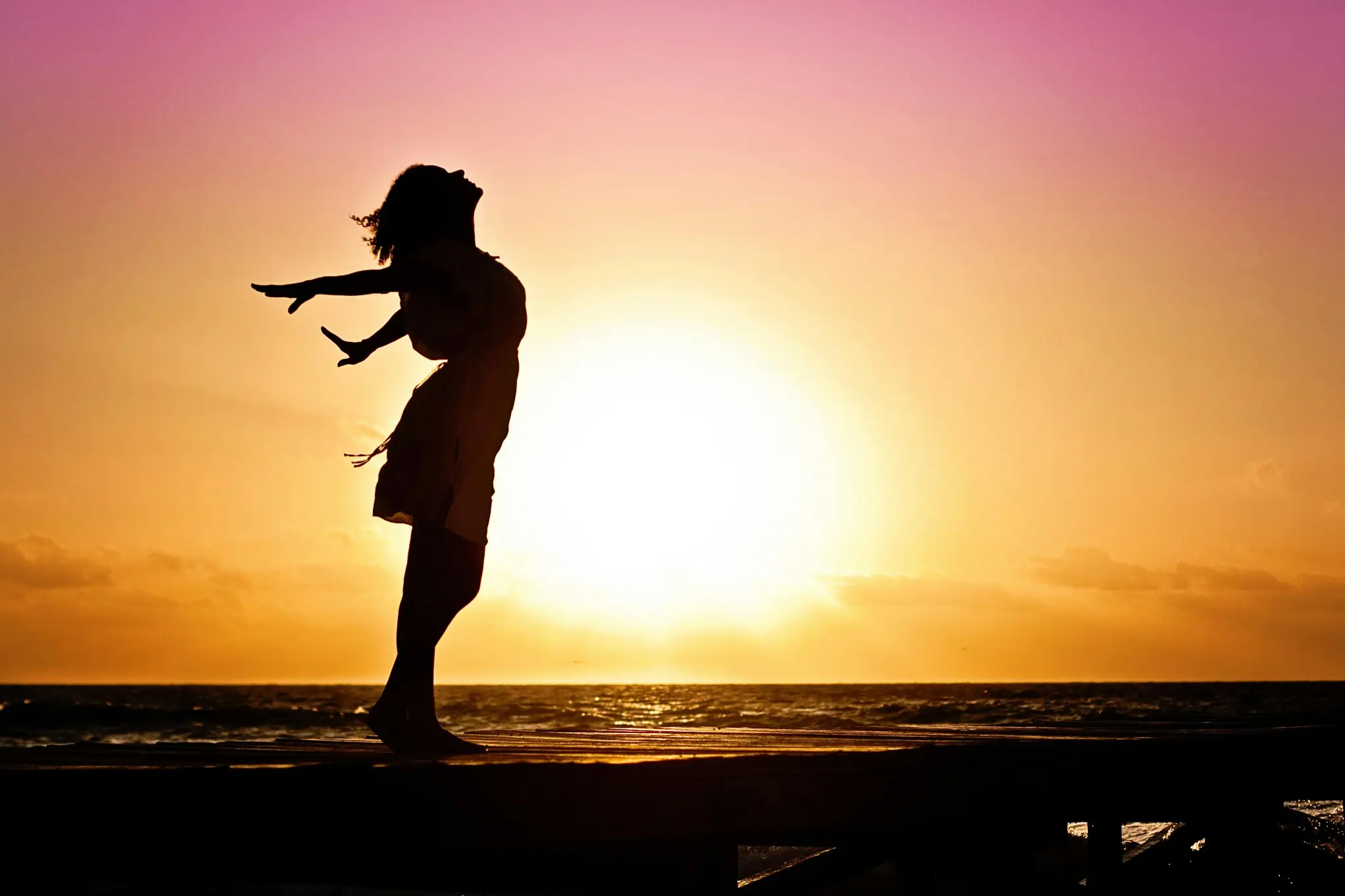 Girl enjoying on the beach at sunset